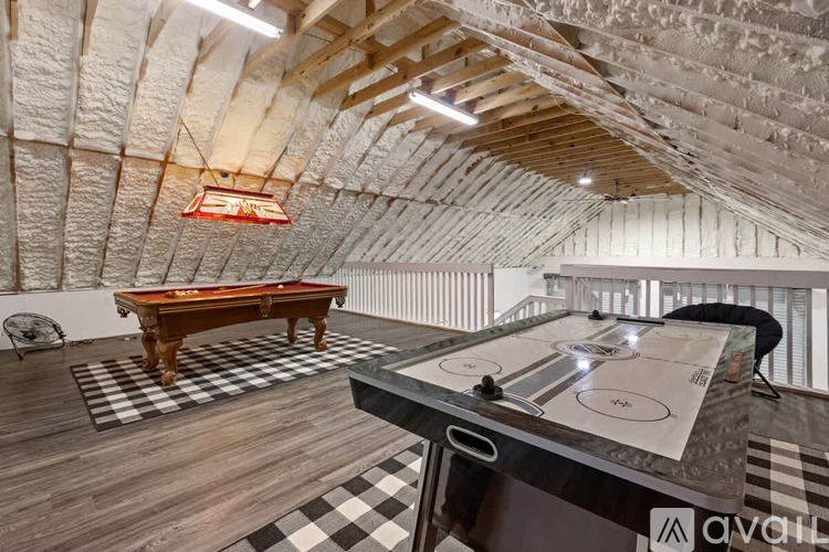 A pool table in a room with a brick wall and wooden ceiling.