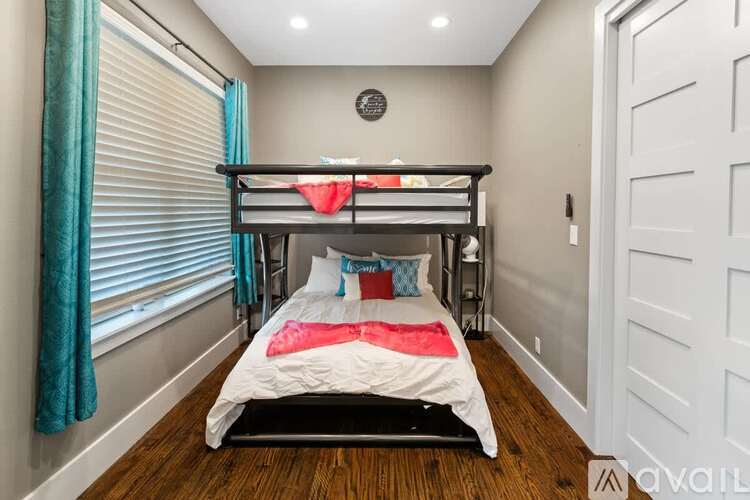 A bedroom with a bunk bed and a window with blue curtains.