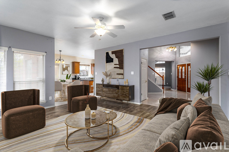 A living room with a glass coffee table and a brown couch.