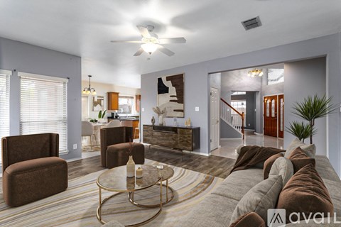 A living room with a glass coffee table and a brown couch.
