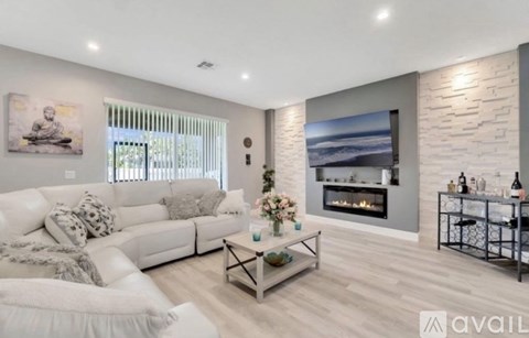 A modern living room with a fireplace and a large painting on the wall.
