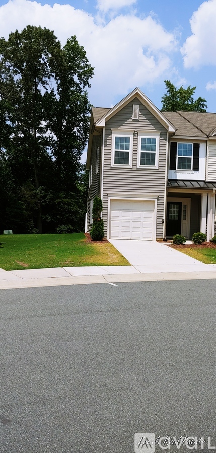 A house with a grey roof and a white garage door.