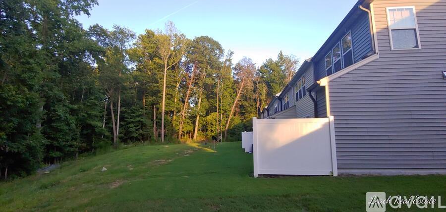 A house with a white fence is surrounded by trees.
