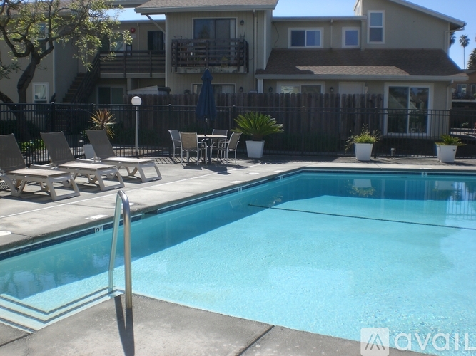 A pool with a diving board in front of a house.