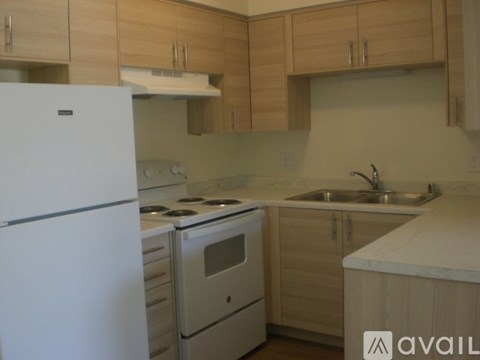 A kitchen with a white fridge, stove, and oven.