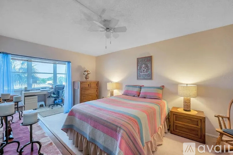 A bedroom with a bed, desk, and chair.