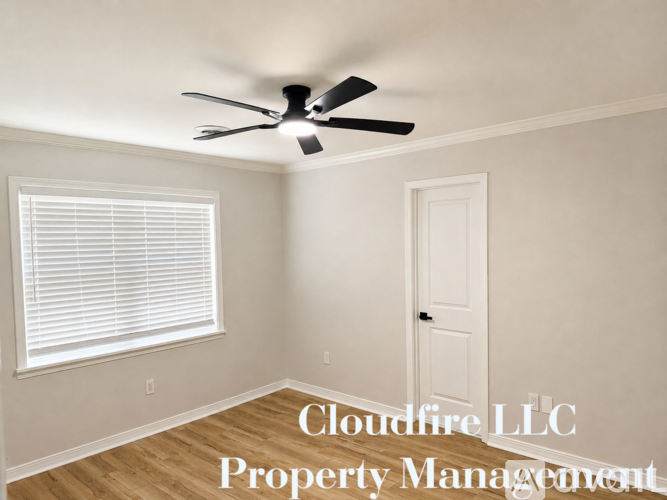 A room with a ceiling fan and a window with blinds.