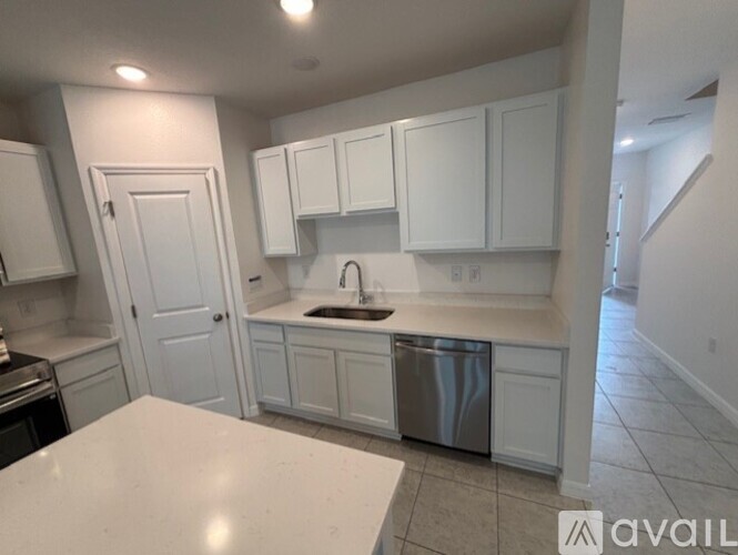A kitchen with white cabinets and a stainless steel dishwasher.