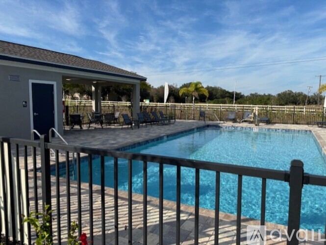 A pool with a fence around it and a building in the background.