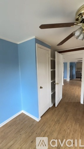 A room with a ceiling fan and light fixture.