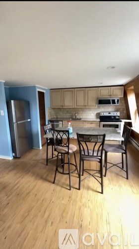 A kitchen with a table and chairs.