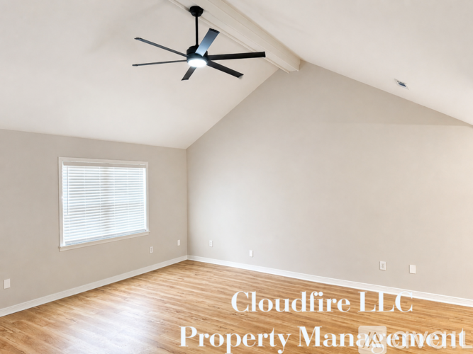 A room with a ceiling fan and Cloudflare LLC Property Management written on the wall.