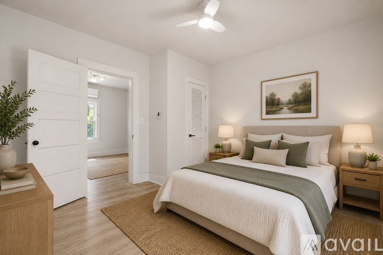 A bedroom with a bed, nightstands, and a plant.