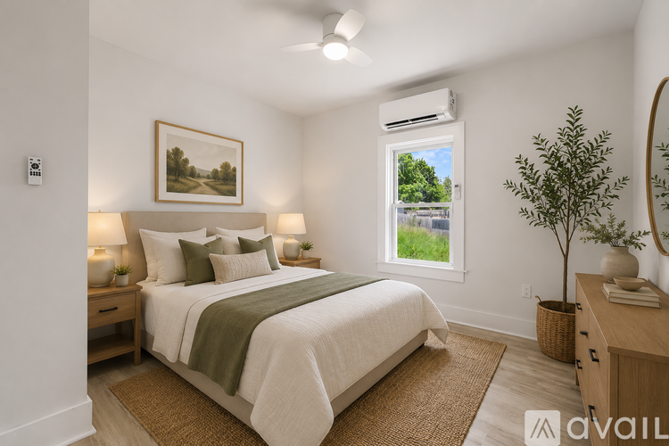 A bedroom with a bed, nightstand, and a painting on the wall.
