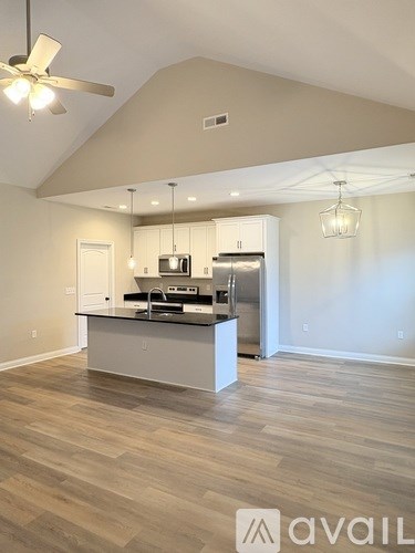 A kitchen with a black countertop and white cabinets.