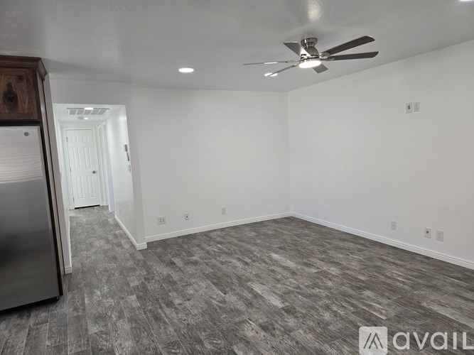 A spacious room with a ceiling fan and a grey carpet.
