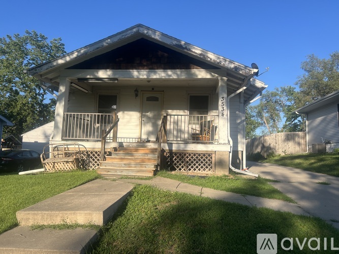 A white house with a porch and a sign that says "AVAIL".