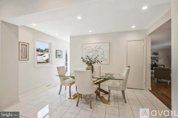 A dining room with a white table and chairs.