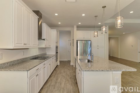 A kitchen with white cabinets and a granite countertop.