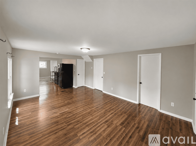 A spacious room with wooden floors and white walls.