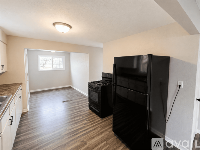 A kitchen with a black fridge and a window.