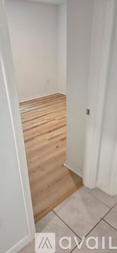 A room with wooden flooring and white walls.