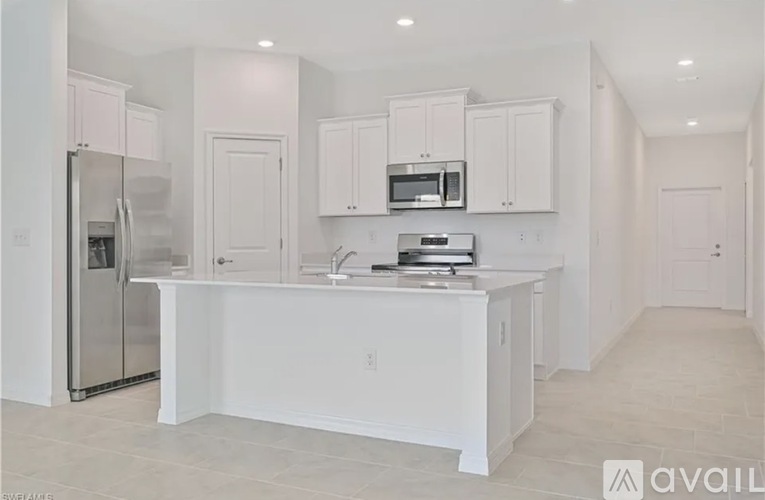 A kitchen with white cabinets and appliances, including a refrigerator, microwave, and oven.