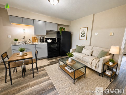 A well-lit kitchen and living room with a dining table and chairs.