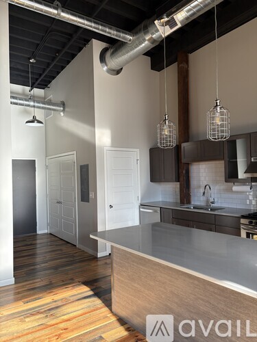 A kitchen with a wooden floor and a counter with a sink.