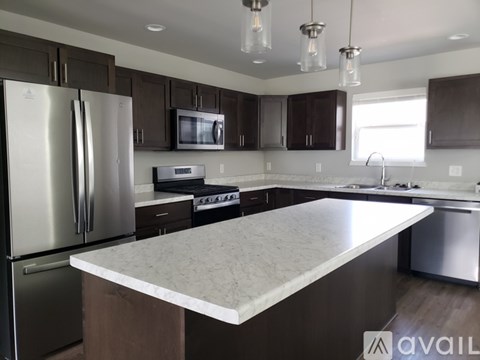 A kitchen with a white island in the middle.