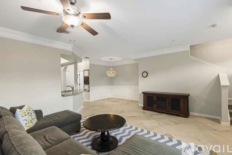 A living room with a grey couch and a black coffee table.