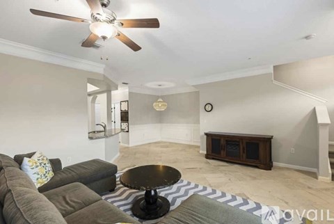 A living room with a grey couch and a black coffee table.