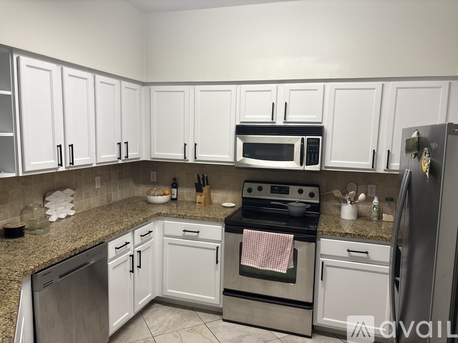 A kitchen with white cabinets and a granite countertop.