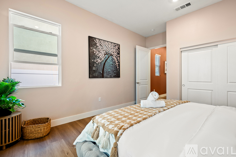 A bedroom with a large bed and a painting on the wall.