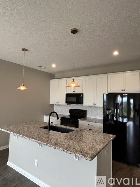 A kitchen with granite countertops and white cabinets.