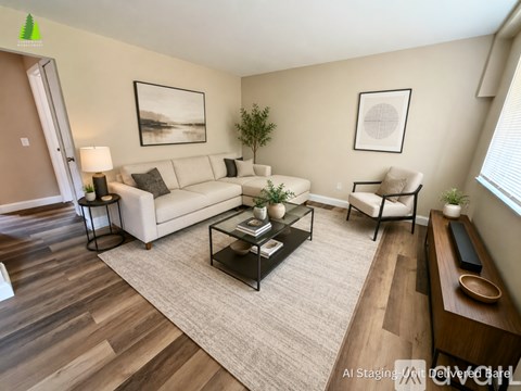 A living room with a white couch, a coffee table, and a painting on the wall.