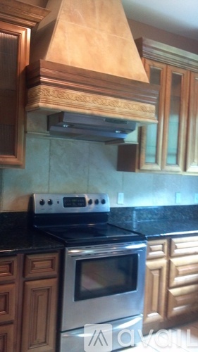 A kitchen with a stove top oven and a range hood.