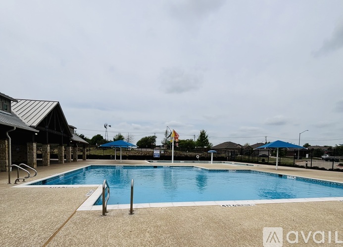 A large outdoor swimming pool with a blue tarp and flags in the background.