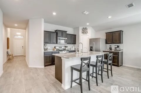 A modern kitchen with a center island and bar stools.