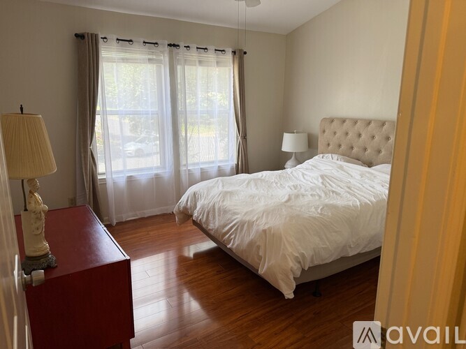 A bedroom with a large bed and a red dresser.