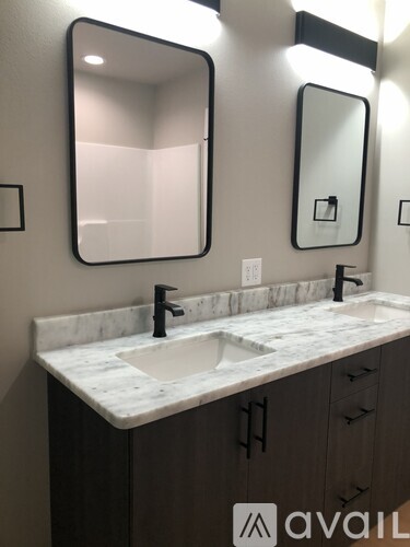 A bathroom with a marble countertop and two sinks.