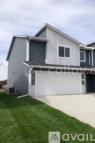 A modern house with a grey exterior and a white garage door.