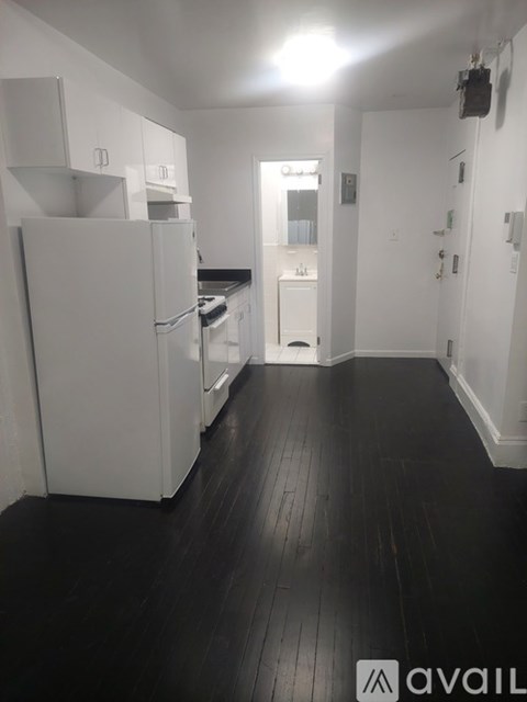 A kitchen with white appliances and black flooring.