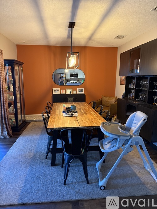 A dining room with a wooden table and chairs.