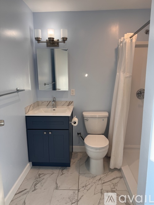 A bathroom with a sink, toilet, and a mirror.