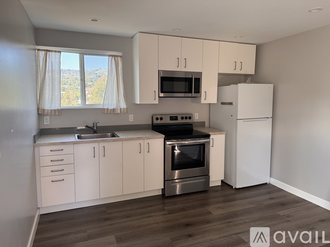 A kitchen with white cabinets and a stainless steel oven.