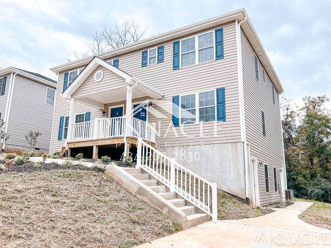 A two-story house with a front porch and stairs leading up to it.