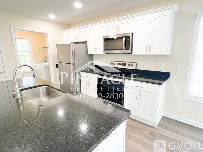 A kitchen with granite countertops and white cabinets is on the market.