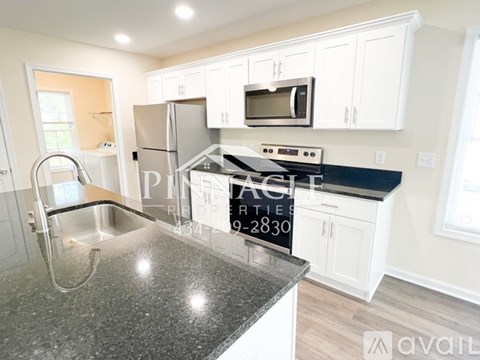 A kitchen with granite countertops and white cabinets is on the market.
