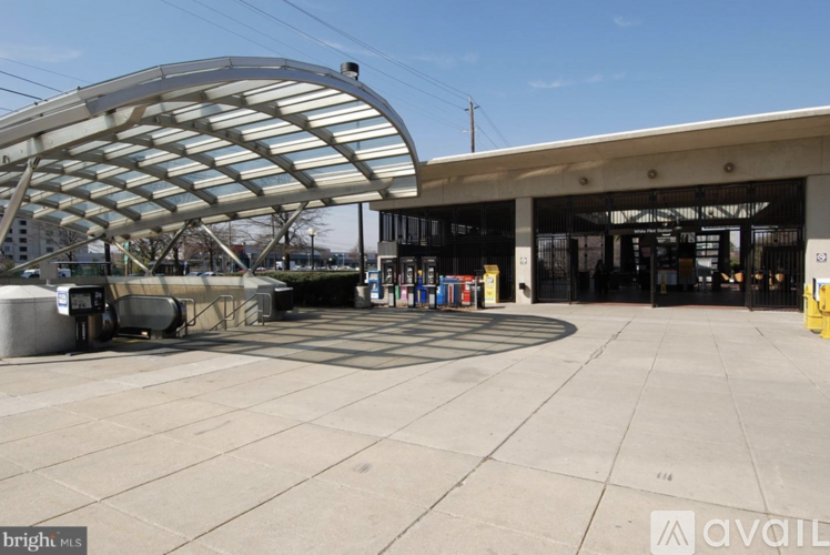 A modern building with a curved roof structure and a covered walkway.